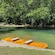A wooden raft docked alongside a verdant riverbank
